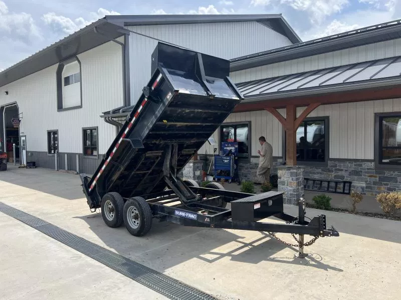 USED Sure-Trac 6x12' Dump Trailer 9900# GVW * SCISSOR HOIST * ADJUSTABLE COUPLER * UNDERMOUNT RAMPS * COMBO GATE * 7K DROP LEG JACK * FRONT/REAR BULKHEAD * INTEGRATED KEYWAY * SPARE MOUNT * HD FENDERS * 4" TUBE BEDFRAME * TRIPLE TUBE TONGUE * POWDERCOATED