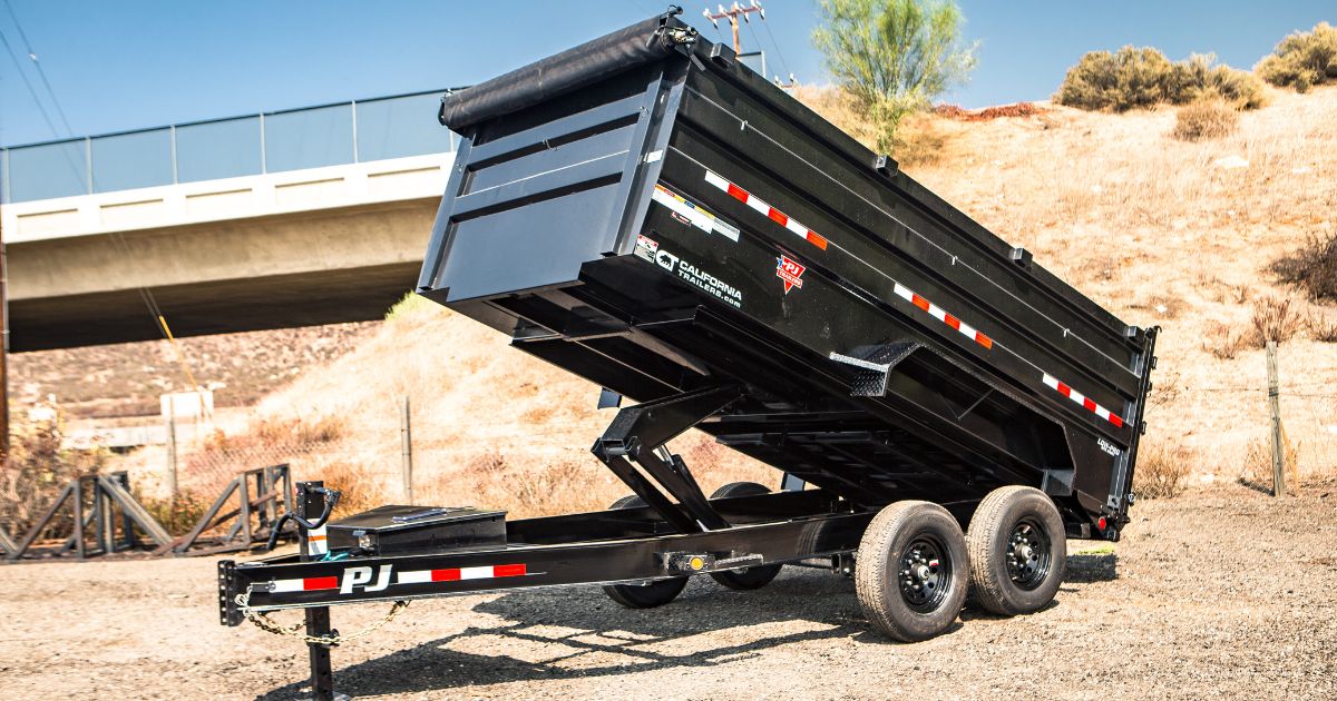 A black dump trailer with its bed raised, parked outdoors on dry ground. Well-maintained, emphasizing the importance of rust prevention to keep used trailers durable and functional." width="1200" height="630