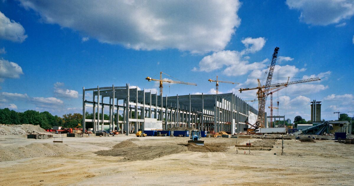A construction site that prioritizes job site safety, with cranes and blue sky in the distance. " width="1200" height="630
